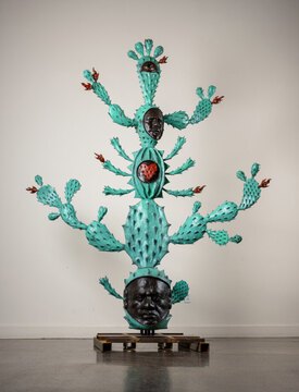 Totem-esque light green cacti with faces interspersed within the body.